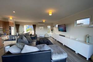 ein Wohnzimmer mit einem Sofa und einem TV in der Unterkunft Jan Juc Ocean Views - Pet friendly in Torquay