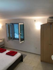 a bedroom with a bed and two windows at Etno village Mihailovic in Herceg-Novi