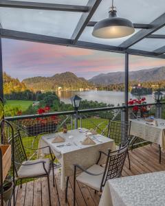 a patio with tables and chairs and a view of a lake at Hotel Triglav in Bled