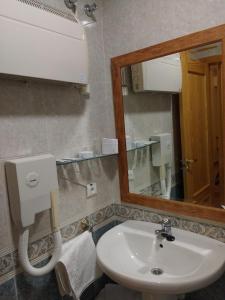 La salle de bains est pourvue d'un lavabo et d'un miroir. dans l'établissement Hotel Mesón el Castillo, à Banyeres de Mariola
