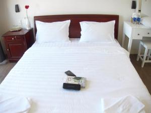een slaapkamer met een wit bed met een doos erop bij Lama Homestay in Hue