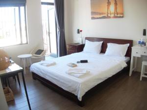 1 dormitorio con 1 cama grande con sábanas blancas en Lama Homestay en Hue