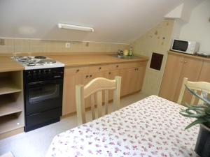 cocina con fogones y mesa con sillas en Apartma Cvetek, Srednja vas 133, en Bohinj