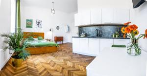 a kitchen with white cabinets and a wooden floor at 2BCOMFY - Barlickiego in Bielsko-Biała