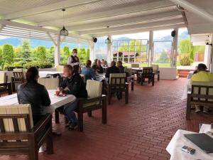 a group of people sitting at tables in a restaurant at VILA Restaurant Transilvania in Zărneşti