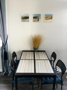 a dining room table with chairs and a potted plant at City Apartment in Klaipėda