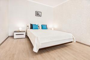 トリヤッチにあるSpring Melody Apartment SUTKI LIFEの白いベッドルーム(青い枕の大型ベッド付)