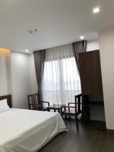 a bedroom with a bed and a table and a window at SUN HOTEL & APARTMENT in Bắc Ninh