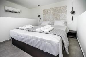 sypialnia z dużym łóżkiem z dwoma ręcznikami w obiekcie Villa Daniela & Apartments w mieście Koutsounari +37 zdjęć
