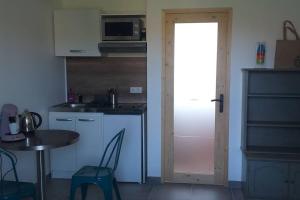 a kitchen with a table and a door leading into a kitchen at Les Embruns studio ancien corps de ferme plage in Criel-sur-Mer