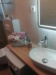 La salle de bains est pourvue d'un lavabo et d'un panier de serviettes. dans l'établissement Apartman "Roko", à Zadar