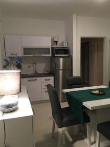 una cocina con mesa y sillas y una cocina con mesa y sillón. en Apartmani Nada, en Novalja