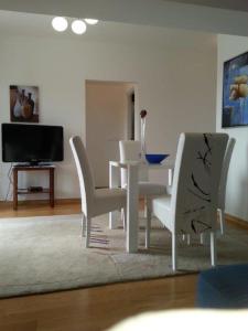 a dining room with a white table and chairs at Apartmani Nada in Novalja