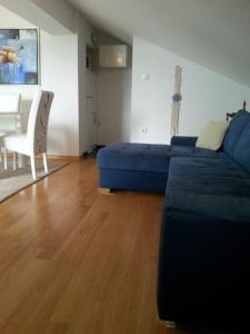Apartmani Nada في نوفاليا: غرفة معيشة مع أريكة زرقاء وطاولة