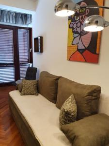 eine Couch in einem Wohnzimmer mit einem Gemälde an der Wand in der Unterkunft Apartmani Nada in Novalja