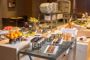 um buffet com muitos tipos diferentes de pastelarias e sobremesas em Holiday Inn Hangzhou Gongshu, an IHG Hotel em Hangzhou