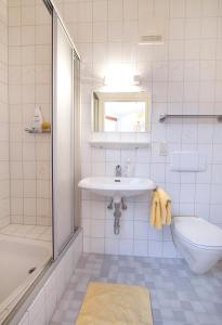 a white bathroom with a sink and a toilet at Hotel zur Sonne in Korneuburg