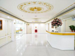 a large white lobby with a ceiling with a vase of flowers at Khách Sạn Phượng Hoàng 3 in Thanh Hóa