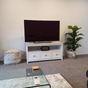 a white entertainment center with a flat screen tv on it at One central apartments city centre in Christchurch