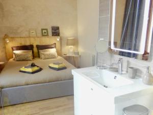 a bedroom with a bed with a sink and a mirror at La Couette Enchantée - Parking - Zimmerbach in Zimmerbach