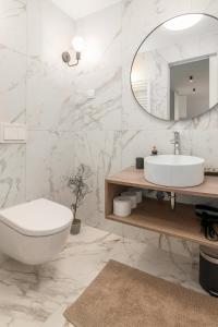 a white bathroom with a sink and a mirror at OPN Apartments Bled in Bled +96 photos