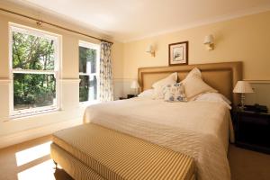 a bedroom with a large bed and two windows at The Dower House Hotel in Woodhall Spa