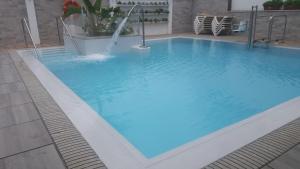 una gran piscina azul con una fuente en Hostal La Ermita, en Nerja