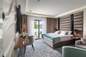 Love Sopot Residence في سوبوت: غرفة الفندق بسرير ومكتب واريكة