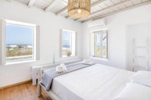 1 dormitorio blanco con 1 cama grande y ventanas en Villa Esencia, en Agios Ioannis Mykonos 29 fotos más