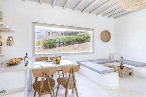 sala de estar blanca con mesa y sofá en Villa Esencia, en Agios Ioannis Mykonos