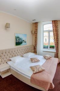 a bedroom with a large white bed with a window at Hotel 52 in Odesa