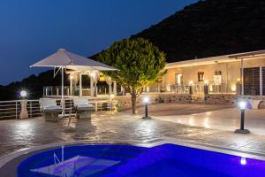 a swimming pool in front of a building at night at Promitheas Villa, Sea Side Resort, By ThinkVilla in Vlikhádha