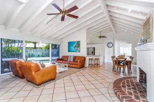 a living room with leather furniture and a ceiling fan at Island living in the heart of Noosa in Noosa Heads