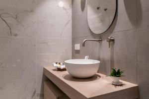 a bathroom with a bowl sink and a mirror at Sicilia's Art Hotel & Spa in Acitrezza