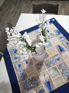 una mesa con flores azules y blancas en un jarrón en Case marino, en Termini Imerese