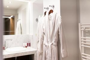a bathroom with a white robe hanging on a rack at Hôtel Merveilleux Côté Mer in Dunkerque