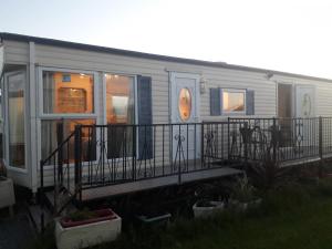 a mobile home with a porch and a railing at Mablethorpe L17 Caravan in Mablethorpe
