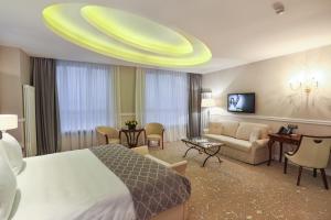 una camera d'albergo con letto e divano di Hotel International Iasi a Iaşi