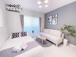 uma sala de estar com uma cama e um sofá em OUCHI HOTEL Hatsukaichi-Ekimae em Hatsukaichi