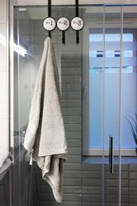 - une serviette suspendue à une porte en verre dans la salle de bains dans l'établissement Apartament Studzienna 18, à Szczecin