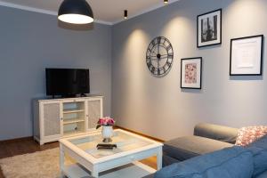 un salon avec un canapé bleu et une télévision dans l'établissement Apartament Studzienna 18, à Szczecin