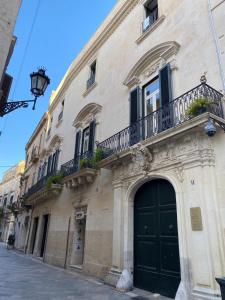 a building with a green door and a balcony at Palazzo Rollo in Lecce