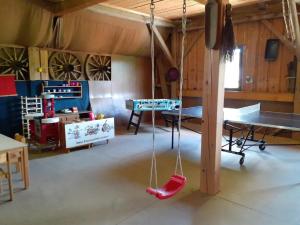 a room with a ping pong table and a swing at Mattheishof in Grafenau