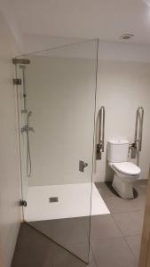a bathroom with a toilet and a glass shower stall at Albergue Peregrinos San Francisco de Asis in León +39 photos