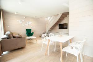 a living room with a white table and chairs at Domki Amber House in Dźwirzyno