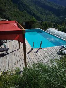 a large blue swimming pool on a wooden deck at Le box joli pavillon indépendant et privatif in Rigaud