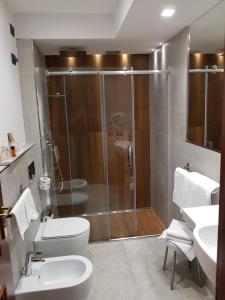 een badkamer met een douche, een toilet en een wastafel bij Corsaro Etna Hotel&SPA in Nicolosi