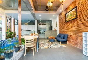 a lobby with a brick wall and chairs and a table at HOI AN HEART LODGE in Hoi An