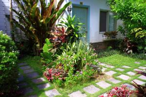 a garden in front of a house with flowers at Sunshine Bungalow in Phu Quoc