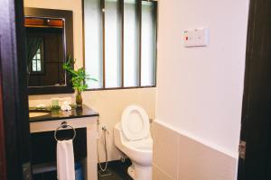 a bathroom with a toilet and a sink and a mirror at Mutiara Taman Negara in Kuala Tahan